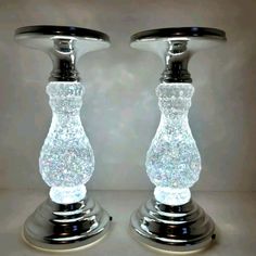 two glass candlesticks sitting on top of each other