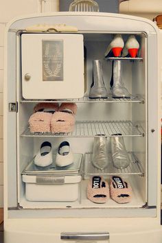 an open refrigerator with shoes and other items in it