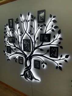 a tree with many pictures hanging on it's sides and lights around the branches