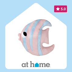 a pink and blue fish shaped pillow with the words at home on it's side