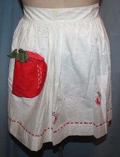 a white skirt with a red strawberry on the front and green apple on the back