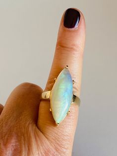 When you gaze into this stone, it feels as if you've been drawn into a little galaxy. A galaxy that is mesmerizing, mystical, and magical! You may even loose track of time while peering into this lovely gift from the earth. -The center stone is a marquise cut natural opal measuring 30mm X 10mm X 7.5mm.  -The shank is 14k yellow gold. -The total weight of the ring is 9.6 grams. -Ring Size 9.25.  Seller is a GIA Graduate Gemologist. Yellow Gold Opal Ring, Open Heart Necklace, Opal Ring Gold, Cabochon Ring, Vintage Perfume, Brass Jewelry, Smokey Quartz, Marquise Cut, Natural Opal