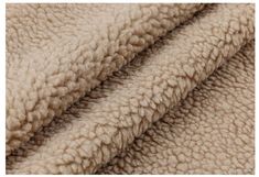 a close up view of the texture of a blanket in light brown and beige tones