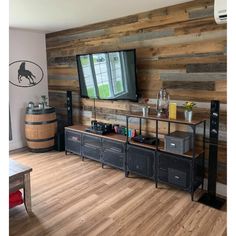 a living room with wood paneling and a television on top of the entertainment center