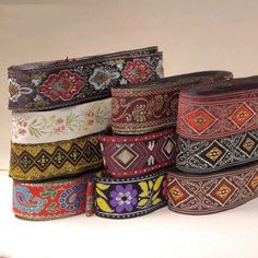 a bunch of different colored belts stacked on top of each other in front of a white background