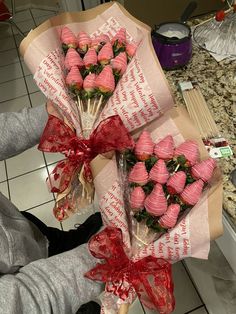 a bunch of strawberries wrapped in paper and tied with red ribbon on top of a counter