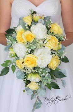 a bride holding a bouquet of yellow and white flowers