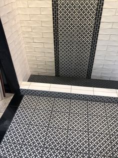 a black and white tiled shower stall in a bathroom