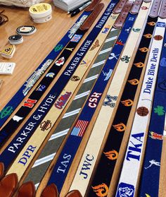 many different colored belts are lined up on a table next to some shoes and other items