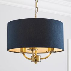 a blue and gold chandelier hangs from a ceiling fixture in a room with white walls