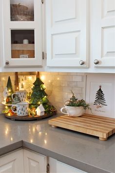 the kitchen counter is decorated for christmas with small trees and other holiday decorations on it