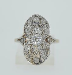 A lovely white and Yellow gold setting houses the array of fine diamonds. The center diamond is an Old European Cut diamond. It measures in at 1/3 of a carat (0.33). The center diamond is in a bezel setting of 18K white gold. Surrounding the OEC Diamond are rose-cut diamonds also set in white gold. The rose cuts are milligrain set into the open work design. The gallery is also done with a lovely openwork to allow for maximum light reflection. The gallery and band are in 18K yellow gold. All of t White Diamond Ring With Rose Cut, Art Deco Diamond White Ring With Bezel Setting, Art Deco White Diamond Ring With Bezel Setting, White Marquise Cut Diamond Ring With Single Cut Diamonds, Exquisite White Diamond Cut Diamond Ring, Classic White Diamond Ring With Rose Cut, Exquisite Rose Cut Diamond Anniversary Ring, White Oval Diamond Ring With Single Cut Diamonds, White Diamond Ring With Single Cut Oval Diamonds