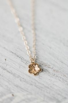 Solid 14k gold cherry blossom charm necklace. A delicate and beautifully detailed charm. Cherry blossoms are a symbolic flower of spring, a time of renewal, and the fleeting nature of life. In Japanese culture the cherry blossom represents the fragility and the beauty of life. Available with a solid gold chain, gold filled chain or as a charm only. Charm comes with a 4mm jump ring, if you would like a spin ring clasp to add to your charm bracelet feel free to contact me.✥  14K Solid gold (charm Dainty Blossom Jewelry For Spring, Dainty Blossom Color Jewelry For Spring, Dainty Blossom Flower Jewelry, Everyday Flower Necklace With Flower Charm, Cute Flower Necklace With Flower Charm, Spring Gift Gold Jewelry, Cute Necklaces For Spring Gift, Cute Spring Necklace As A Gift, Cute Spring Necklace For Gift