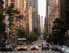 a city street filled with lots of traffic and tall buildings on both sides of it