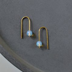 Minimalistic arc earrings with opalite beads. Made from hand bent brass wire. These abstract earrings dangle effortlessly from your earlobes. Perfect for everyday wear! The 1mm brass wire is very stable and I sanded down the ends for a comfortable application. DETAILS: - brass wire - opalite - length: app. 1" - bead width: 0.23"  Herstellerin/ Manufacturer Christine Hornicke, Finkenberg 64, 23558 Lübeck, Germany hello@gudbling.com Back to my shop: https://www.etsy.com/shop/gudbling Photography s Minimalist Opal Earrings, Arch Earrings, Abstract Jewelry, Earrings Minimal, Abstract Earrings, Diy Bookmarks, Jewellery Ideas, Modern Earrings, Fun Earrings