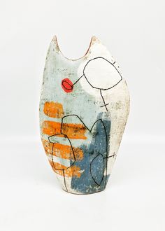 a ceramic vase with an abstract painting on it's face and body, against a white background