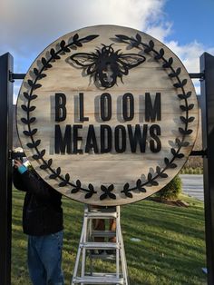 a man standing in front of a sign that says bloom meadows