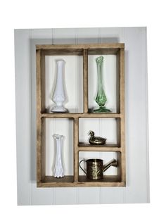 a wooden shelf filled with vases and other items