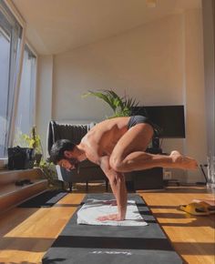 a man standing on one leg while doing a handstand in a living room