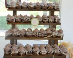 cupcakes are displayed on three tiered trays