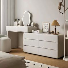 a white dresser sitting next to a bed in a bedroom