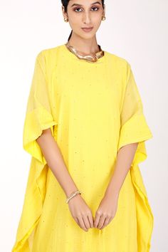 Yellow chanderi kaftan with badla and mukaish embroidery. Comes with a butter crepe inner.
Component: 2
Pattern: Embroidered
Type Of Work: Badla, Mukaish
Neckline: Round
Sleeve Type: Three quarter
Fabric: Kaftan : Chanderi, Inner : Butter crepe
Color: Yellow
Other Details: 
Back button
Note : Necklace worn, potli held by the model is not for sale.
Occasion: Puja - Aza Fashions Chanderi Kaftan With Mirror Work For Festivals, Festival Chanderi Kaftan With Mirror Work, Wedding Chanderi Kaftan With Mirror Work, Festive Chanderi Kaftan With Mirror Work, Yellow Chikankari Embroidered Festive Top, Anarkali Style Gota Work Kaftan For Festive Occasions, Silk Dupatta With Cape Sleeves For Eid, Silk Dupatta For Eid, Festive Silk Kaftan With Cape Sleeves