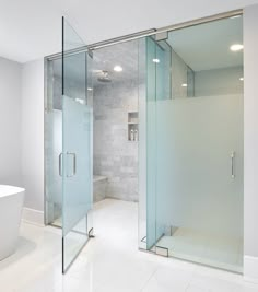 a white bathroom with a glass shower door