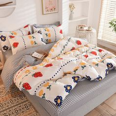 a bed covered in white and blue checkered sheets with fruit print on the comforter