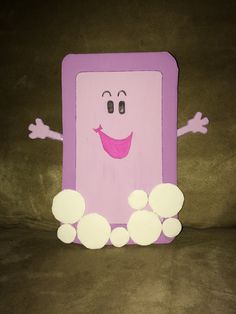 a paper cut out of a pink square with white circles around it and a smiling face