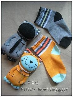 four pairs of socks with cartoon cats on them, all in different colors and sizes