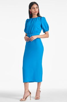 Featuring a fitted bodice, puff sleeve and an added belt, this dress is tailored to hug your curves and flatter any figure. The pop of color in Azure lends an eye-catching finish to the classic look.Details:Model is 5'10" wearing size 254" LongSide Zipper Thick Stretch Crepe92% Polyester - 8% Spandex ImportedStyle #F231D02-439 Fitted Belted Dress With Short Sleeves For Party, Evening Fitted Midi Dress With Belt, Fitted Midi Dress With Belt For Evening, Short Sleeve Belted Evening Dress, Elegant Blue Puff Sleeve Formal Dress, Evening Dress With Belt And Short Sleeves, Chic Belted Dresses With Puff Sleeves, Elegant Blue Fitted Puff Sleeve Dress, Chic Blue Belted Dresses