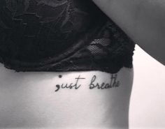 a woman's stomach with the words just breathe tattooed on it