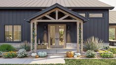 the front entrance to a house with pumpkins and flowers