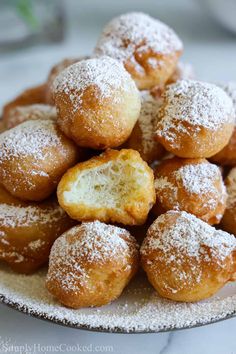 powdered sugar covered donuts on a plate