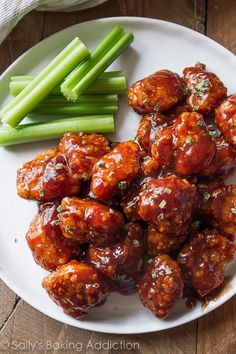 a white plate topped with meatballs and green beans next to celery sticks