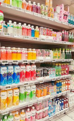 the shelves are filled with many different types of drinks and juices in plastic bottles