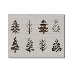 christmas trees are shown on a white wooden board with black and silver foiling, as well as snowflakes