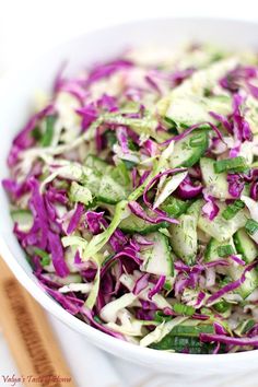 a white bowl filled with coleslaw and cucumbers