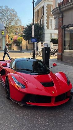 a red sports car parked on the side of the road next to a parking meter