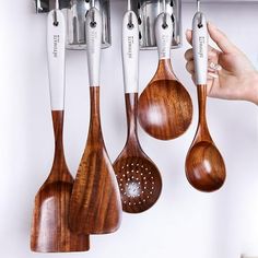 wooden utensils hanging on the wall in a kitchen