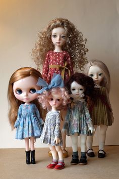 four dolls are standing next to each other