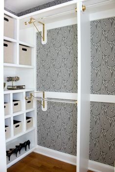 a walk in closet with white shelves and drawers