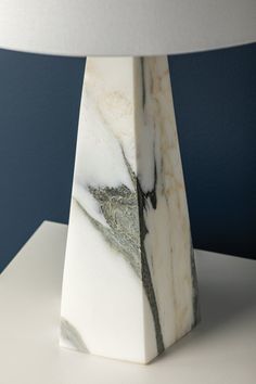 a marble lamp with a white shade on it