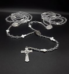 The Silver Wedding Lasso Rosary is an exclusive, special and unique Rosary designed for the special moment in your life. Created for the couple that wishes for a high class wedding lasso Rosary.  In regards to the beads. The beads are made of triple-A high quality Natural Quartz Crystal Beads; completely cleansed and purified. Second, its crosses: there are two types of crosses. The smaller ones that appear along the lasso rosary and are made of the famous Fildisi. The large cross is made of pur White 8mm Beads Jewelry For Anniversary, Handmade Silver Wedding Rosary, Silver Jewelry With 8mm Beads For First Communion, Silver Necklaces With 8mm Beads For Wedding, Silver 8mm Beads Necklaces For Wedding, Silver Round Beads Jewelry For First Communion, Silver Spiritual Jewelry For First Communion, Spiritual Silver Jewelry For First Communion, Spiritual Silver Beads Jewelry For Weddings