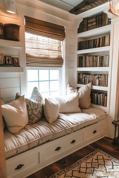 a window seat with bookshelves and pillows on it