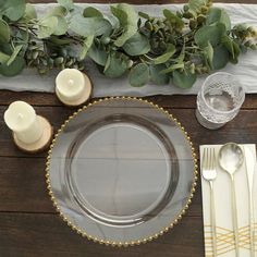 a place setting with silverware and greenery