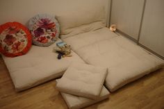 a bed that has been made into a couch with pillows on the bottom and sides