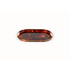 an oval tortoise shell tray with gold rim