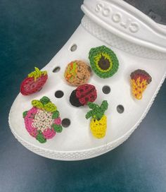 a pair of white shoes with crocheted fruits and vegetables on them