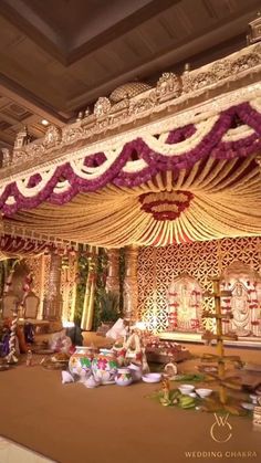 an elaborate stage set up for a wedding ceremony with flowers and decorations on the floor